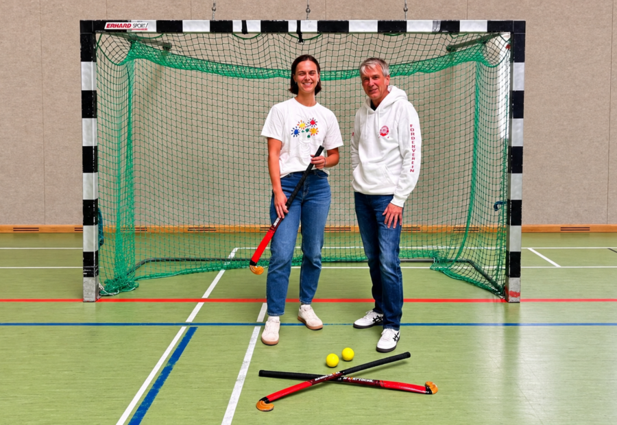 Kira Simon und Christian Ley bei der Übergabe neuer Hallenhockeyschläger in der GAK-Sporthalle