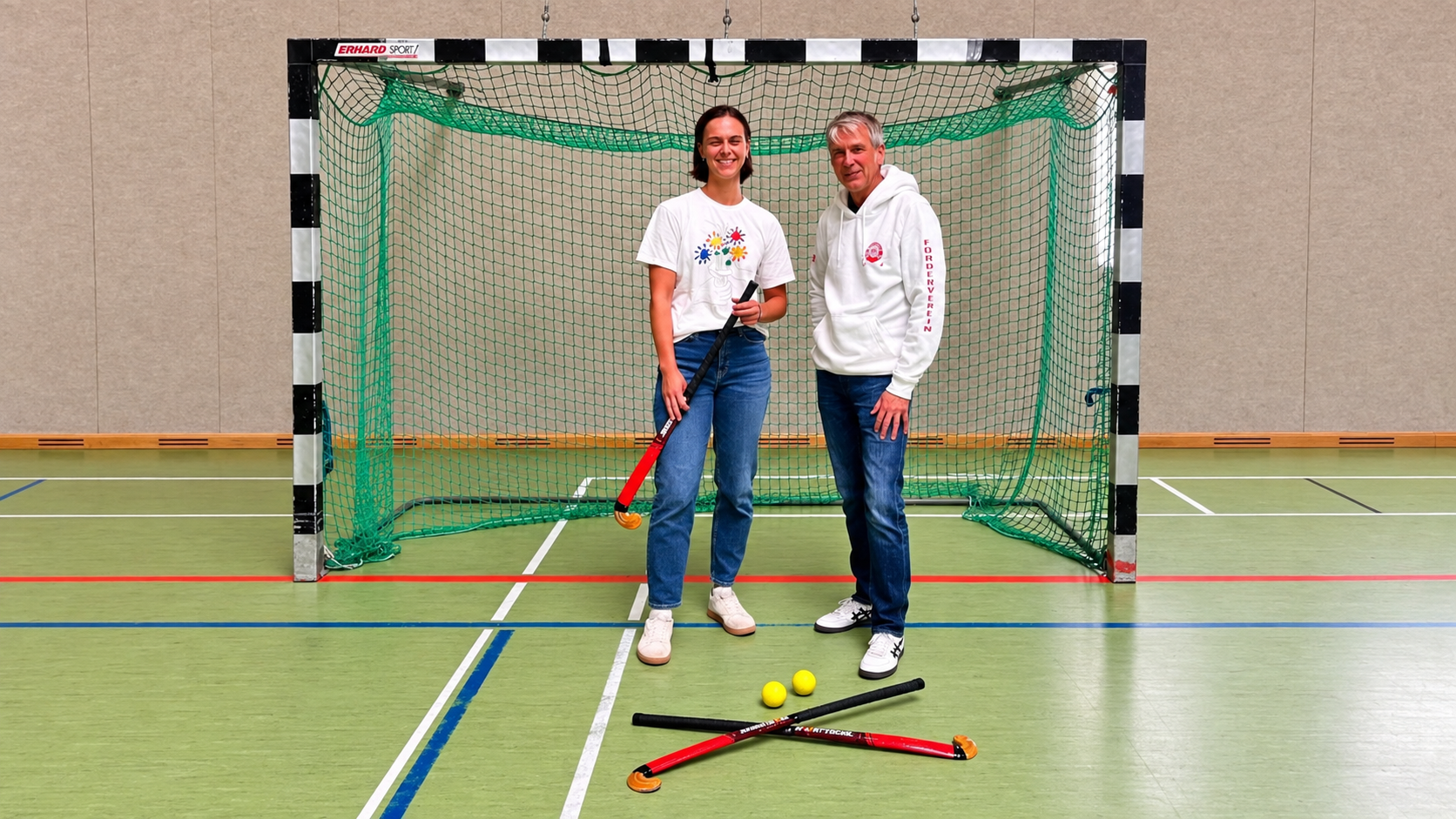 Kira Simon und Christian Ley bei der Übergabe neuer Hallenhockeyschläger in der GAK-Sporthalle